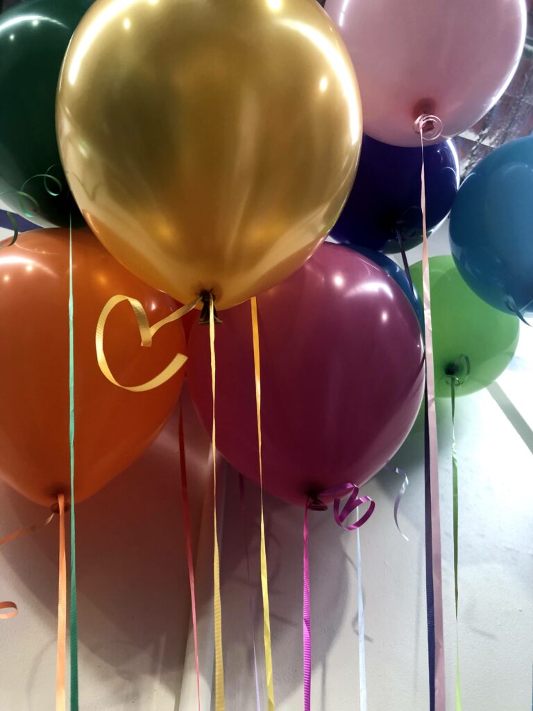 Multiple colours of party balloons floating in the air